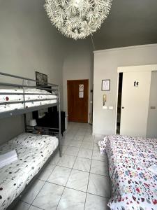 1 Schlafzimmer mit 2 Etagenbetten und einem Kronleuchter in der Unterkunft Camera Privata con Bagno zona ospedale in Pontedera