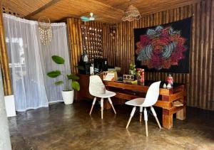 a desk with two white chairs in a room at Bohol Island Homestay in Dauis