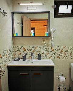 bagno con lavandino e specchio di Chateau Ateni Cottages a Gori