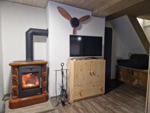 a living room with a wood stove and a tv at Objevte krásu Beskyd , navštivte chatu Lojza in Staré Hamry
