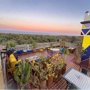 a balcony with tables and chairs and cacti at Riad Chay & Boutique in Ouarzazate
