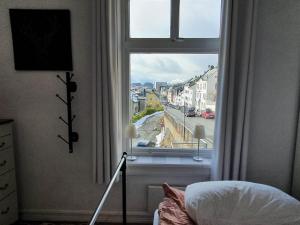 a bedroom with a window with a view of a street at Cozy, Central, Ocean View in Ålesund