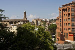 un perfil urbano con una torre de reloj a lo lejos en Hotel Clemente, en Barbastro