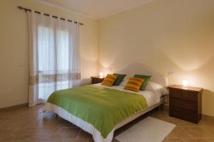 1 dormitorio con 1 cama con almohadas amarillas y verdes en Le Perle Di Golfo Aranci, en Golfo Aranci