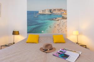 a bed with a hat and a view of a beach at Villa Erna in Dubrovnik