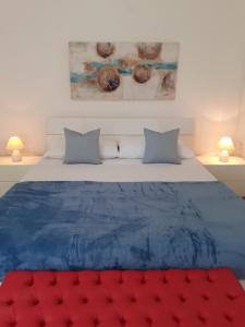 a bedroom with a blue bed with two lamps at Villetta dei Fiori, vicino Spiaggia di Punta Pizzo in Gallipoli