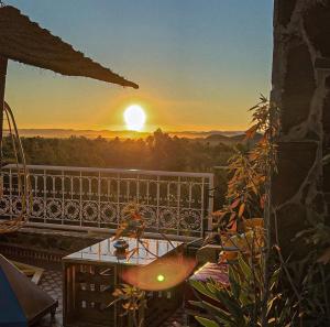 a view of a sunset from a balcony with a table at Riad Chay & Boutique in Ouarzazate