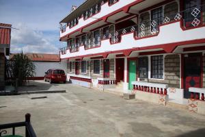 a building with a red car parked in front of it at Furnished Apartments in Nairobi 14km from Jomo Kenyatta International Airport and SGR in Embakasi