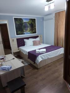 a hotel room with a bed and a desk and a bed sidx sidx at CASA IV in Vama Veche