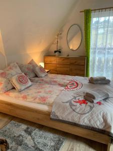 a bedroom with a bed with a dresser and a mirror at Domek u Zosi in Gliczarów