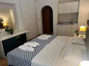 a bedroom with a large white bed with towels on it at Golden days in Afantou