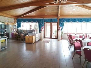 a dining room with tables and chairs and windows at Kervan Tatil Köyü in Edremit