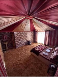 a bedroom with a bed in a room with curtains at The sunset of Wadi Rum in Wadi Rum