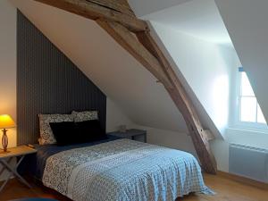 a bedroom with a bed in an attic at B&B Côté Loire in Les Rosiers