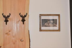 un mur blanc avec une photo sur un mur avec des têtes de cerfs dans l'établissement Les bouquetins, à La Clusaz