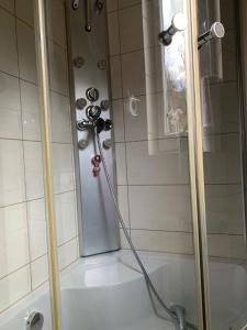 a shower with a hose hooked up to a bath tub at Domek u Zosi in Gliczarów