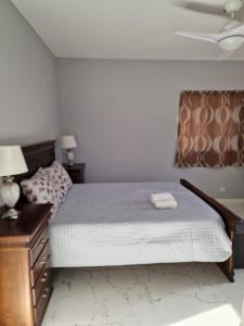 ein Schlafzimmer mit einem Bett, einer Kommode und einer Decke in der Unterkunft Daisy's place in Arcos de Valdevez