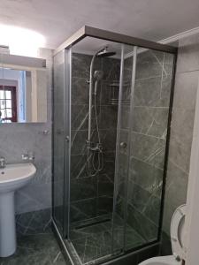 a shower with a glass door in a bathroom at Periklis House in Nea Kalikratia