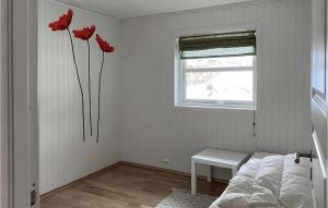 ein Schlafzimmer mit roten Blumen an der Wand in der Unterkunft Nice Home In Farsund With Kitchen in Farsund