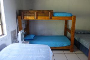 two bunk beds in a small room with a bed at Eagles Nest hostel plus self catering private units in Coffee Bay