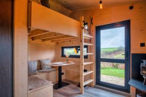 a tiny house with a desk and a window at Luxury Glamping Cabin with Outdoor Bath on Cornish Flower Farm in Truro