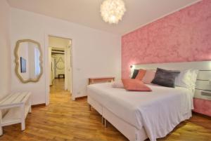 a bedroom with a large bed with a pink wall at Casetta Mazzini in Rapallo