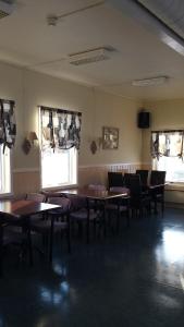 una sala da pranzo con tavoli, sedie e finestre di Tana Vertshus a Bånjakas