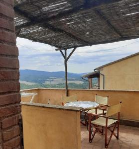 a table and chairs on a balcony with a view at Borgo di Monte Murlo in Guardistallo