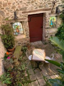 a table and chairs in front of a building with a red door at Studio au charme médiéval in La Garde