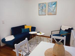 a living room with a blue couch and two chairs at Lauro Apartment in Vienna