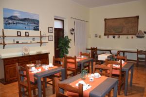 a dining room with tables and chairs and a television at B&B Domus De Janas in Sedini