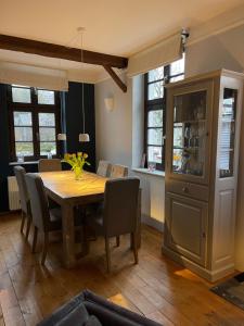 a dining room with a wooden table and chairs at Bürgerhaus Langenberg in Velbert