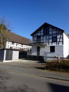 - un bâtiment noir et blanc avec un balcon dans l'établissement Exklusive, kernsanierte Ferienwohnung am Rursee, à Simmerath