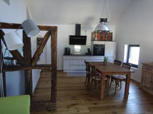 Il comprend une cuisine et une salle à manger avec une table et des chaises en bois. dans l'établissement Exklusive, kernsanierte Ferienwohnung am Rursee, à Simmerath
