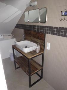 La salle de bains est pourvue d'un lavabo et de 2 miroirs sur le mur. dans l'établissement Exklusive, kernsanierte Ferienwohnung am Rursee, à Simmerath