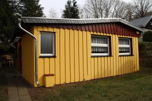 un edificio amarillo con ventana y techo en Ferienhäuser "Zur Hohen Sonne", en Thale