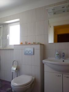 a white bathroom with a toilet and a sink at Oko in Split