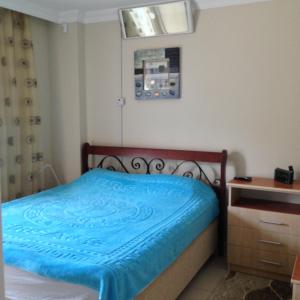 een kleine slaapkamer met een bed met een blauwe deken bij Mirage recidenc 1 in Side