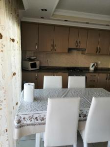 a kitchen with a table with white chairs and a counter at Mirage recidenc 1 in Side