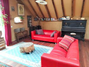 a living room with two red couches and a table at Todo se pasa Yurt in Sauwerd