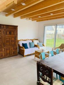 sala de estar con sofá, sillas y mesa en Maison à 100m de la plage, en Brignogan-Plage