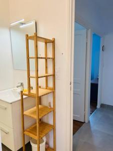 uma casa de banho com uma prateleira de madeira num quarto em Maison à 100m de la plage em Brignogan-Plage