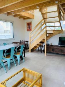 um quarto com uma mesa e cadeiras e uma escada em Maison à 100m de la plage em Brignogan-Plage