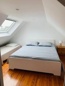 um quarto com uma cama e uma janela num piso de madeira em Maison à 100m de la plage em Brignogan-Plage