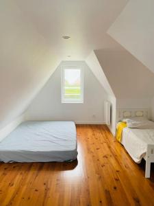 um quarto no sótão com 2 camas e uma janela em Maison à 100m de la plage em Brignogan-Plage