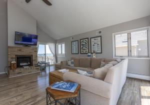 sala de estar con sofá y chimenea en Bay Front Home - Watch the sun rise over LBI. Pier for Boat/Swim/SUP/Kayak/Crab, en Manahawkin