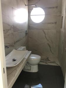La salle de bains est pourvue de toilettes blanches et d'un lavabo. dans l'établissement Casa de Colima, à Colima