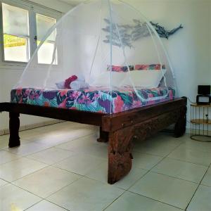 سرير أو أسرّة في غرفة في appartement privé ECO-RESPONSABLE, vue sur la mer des Caraibes et jardin clos, WiFi, à 2mn de la plage