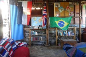 um quarto com bandeiras e livros num quarto em Eagles Nest hostel plus self catering private units em Coffee Bay
