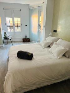 a large white bed with a black bag on it at Piso en el emblemático barrio antiguo de Oviedo in Oviedo